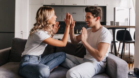 Photo of a young man and woman high-fiving